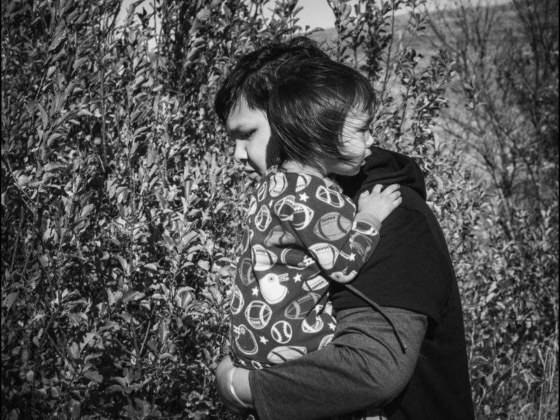 Devin Free Carrying His Little Brother Griffin, Wakpala, Standing Rock Reservation, South Dakota, 2016 by Sue Reynolds