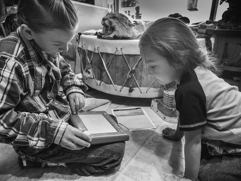 Leo and Eagle Whistle Playing Etch A Sketch, Browning, Blackfeet Reservation, Montana, 2016 by Sue Reynolds